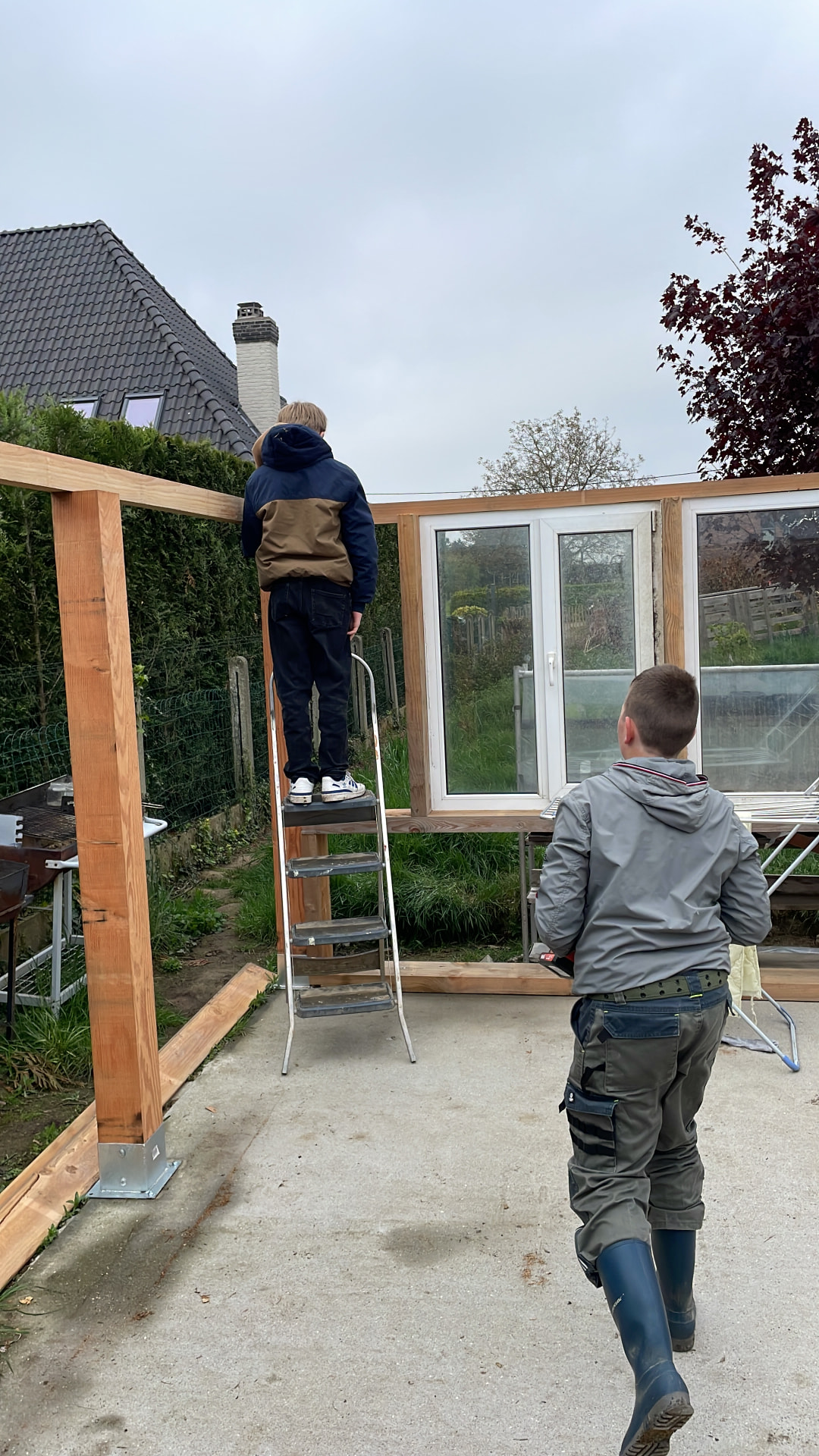 Twee jongeren bouwen samen aan een houten constructie
